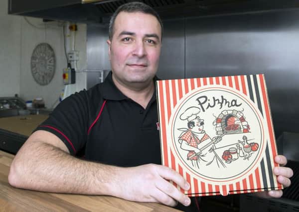Erkan Kinal, of Mozarella's Pizza takeaway, Leicester Avenue, offering a free garlic bread worth Â£3
