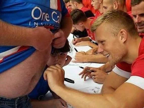 Curtis Main signs Neil Taylor's stomach.