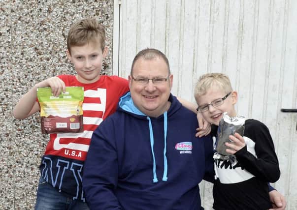 Alan Rayment pictured with sons Thomas, 9, and Harry, 6, holding some of the donations he is taking with him.