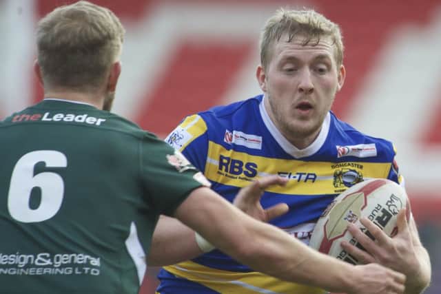 Doncaster's Matty Welham looks to skip the challenge of Ryan Smith.
Picture by Dean Atkins