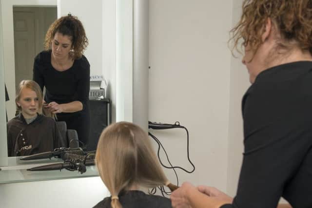 Casey Hunston having her hair cut by Suzanne Thacker for the Little Princess Trust at Barrons salon in Swinton