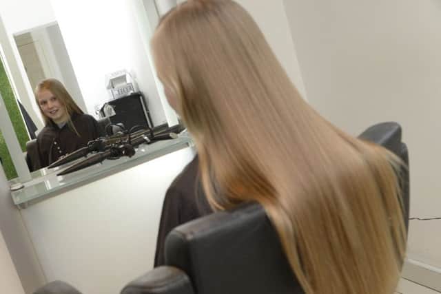 Casey Hunston having her hair cut by Suzanne Thacker for the Little Princess Trust at Barrons salon in Swinton