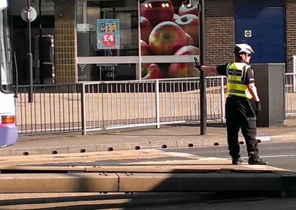 A policewoman directing traffic after a bus broke down on Trafford Way