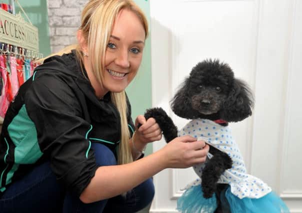 Deborah Hatton, the owner of new dog grooming salon on Manchester Road, Ince, pictured with her dog Bubbles, wearing dog clothes that are for sale in the salon.