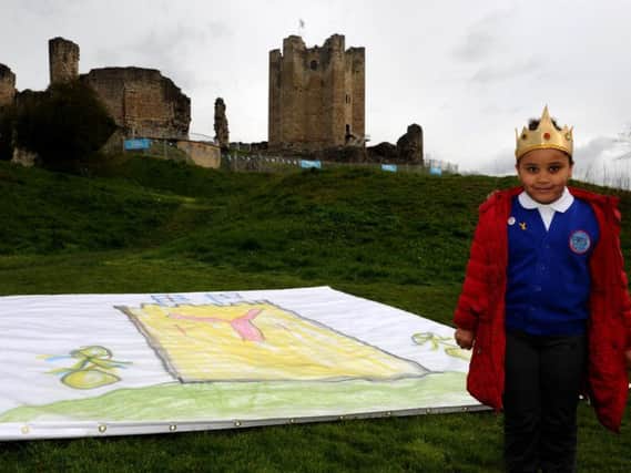 Fatou Njie, five, of Rowena Academy unveils her land art outside Conisbrough Castle for the Tour De Yorkshire.