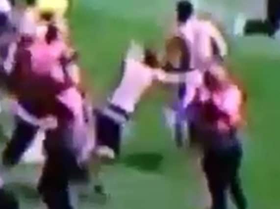 Burton fan Will Bower is sent sprawling onto the Keepmoat pitch after allegedly being chopped down by a Doncaster Rovers steward.