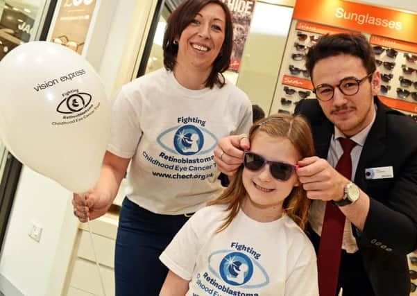 Jane Harrison and her daughter Olivia, seven, CHECT Ambassador, pictured with Viktor Tulev, Optical Apprentice, during the  launch the stores Sunglasses giveaway during World Retinoblastoma Awareness Week.