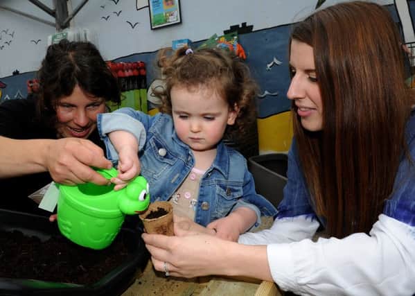 Imogen Farah waters her plant pot with Nik and Victoria Middleton, of Ferndale Garden Centre as part of National Children's Gardening Week, at Ferndale Garden Centre. Picture: Andrew Roe