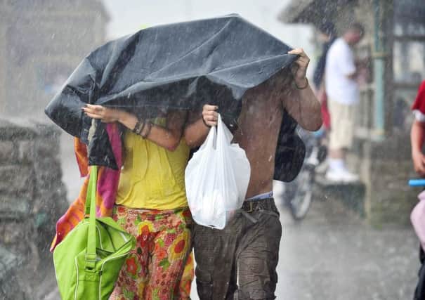 A a couple caught up in a brief summer downpour, as short, sharp downpours could become an increasingly unwanted characteristic of the British summer. Ben Birchall/PA Wire