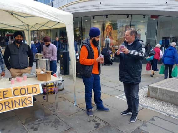 Shoppers pick up their free non-alcoholic drinks in Doncaster town centre.