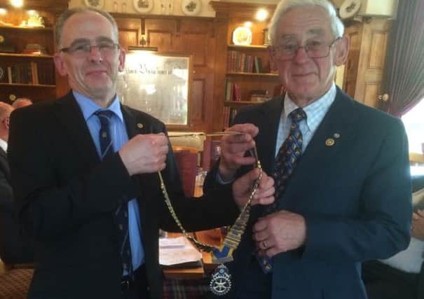 Outgoing Thorne Rotarian president, Peter Haley, hands over the chain of office to his son Richard Haley