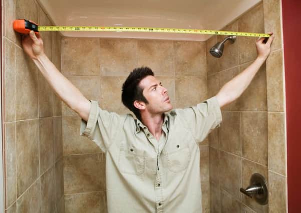 A man measuring up for tiles in the bathroom. Picture: PA Photo/thinkstockphotos.