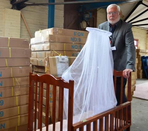 Pictures of unsafe baby cots that could have 'caused strangulation and led to a baby's fingers being cut off' that were seized by Doncaster Council's Trading Standards department. Coun Chris McGuiness is pictured with one of the seized cots.