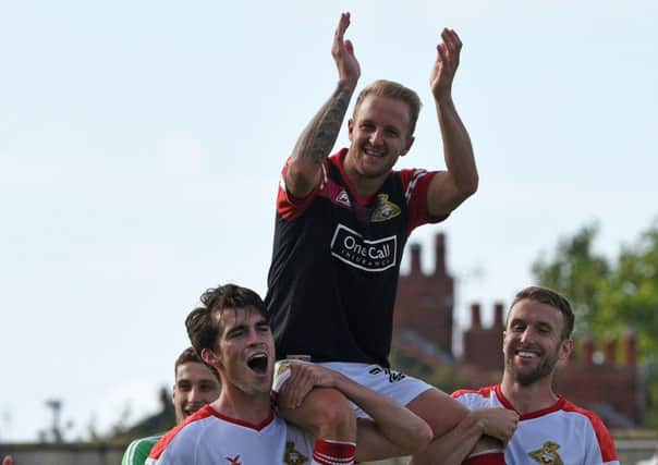 James Coppinger is held aloft by John Marquis and Andy Williams.