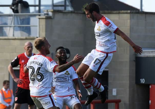 Matty Blair celebrates his goal at Morecambe with James Coppinger and Cedric Evina.