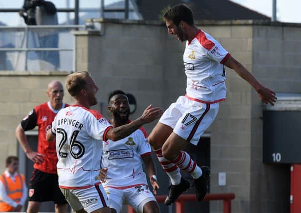 Matty Blair celebrates his goal at Morecambe with James Coppinger and Cedric Evina.