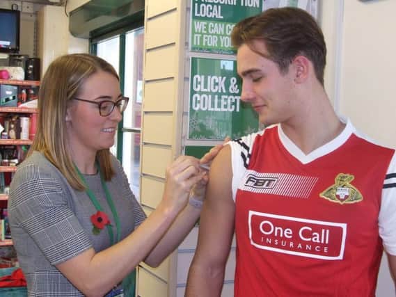 Pharmacist Charlotte Wigglesworth giving Rovers defender Mitchell Lund his flu jab