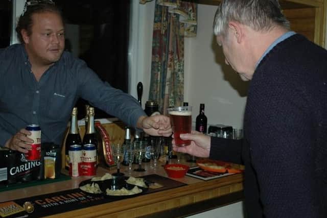 Resident Ray Batty, aged 67, is offered a drink by Jamie Drake as they enjoy a chat at the bar.