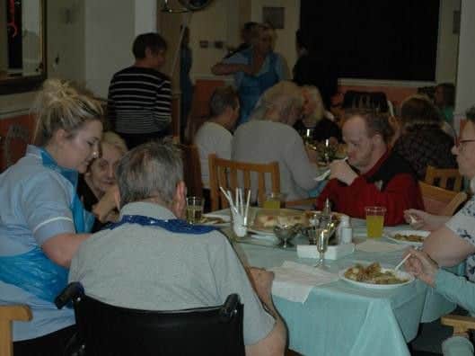Residents and staff tuck in to a pie and peas supper.