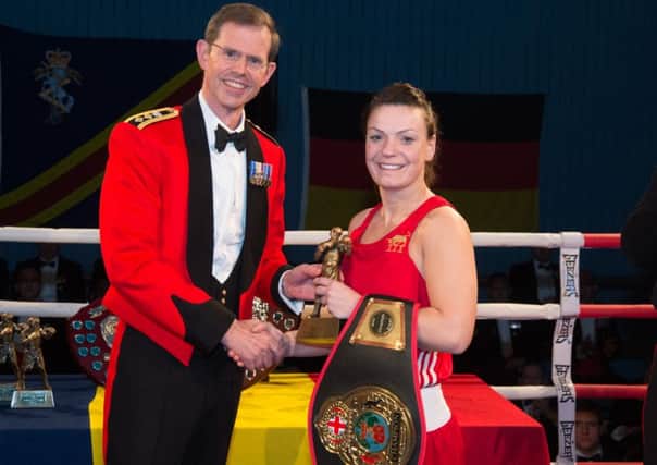 Cpl Donna Anderson receives her winning belt and tophy