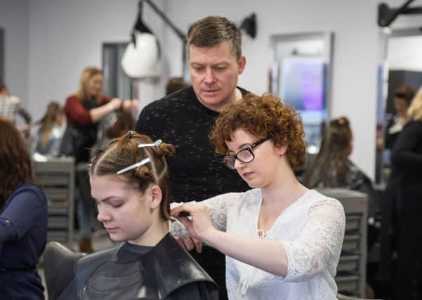 Creative director of McDonald Waterfall hair stylists, Stuart Waterfall, directs student Hannah Wilson, during a hair styling masterclass