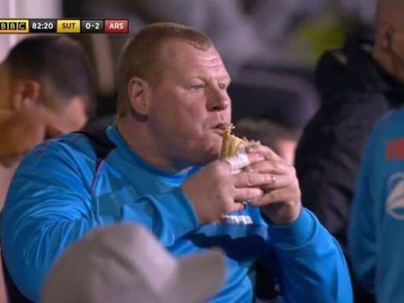 Wayne Shaw tucks into his snack during the Sutton United v Arsenal game.