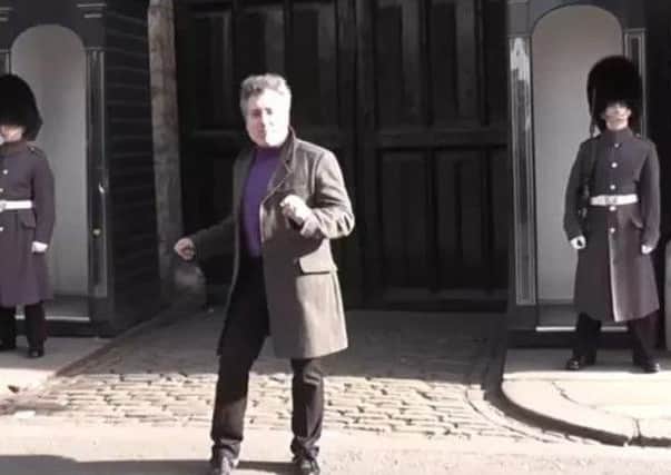 The male tourist dances in comic fashion before a Scots guardsmen makes him think again. (Photo: lokirna md45/YouTube)