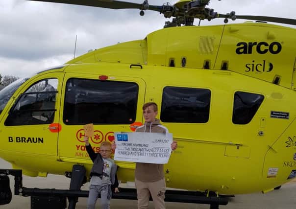 Taylor Bingham with his brother Riley presenting a cheque to Yorkshire Air Ambulance