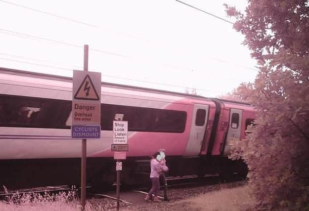 The youngsters were pictured just inches from a fast-moving train.