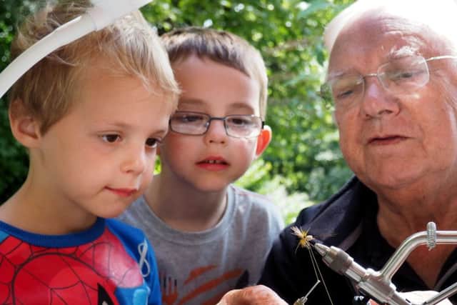 Wardsend Cemetery Bioblitiz and Open Day: David Rowley from the Don Catchment Rivers Trust making a fishing fly watched by Leon Brown (4 - left) and brother Alex (6)