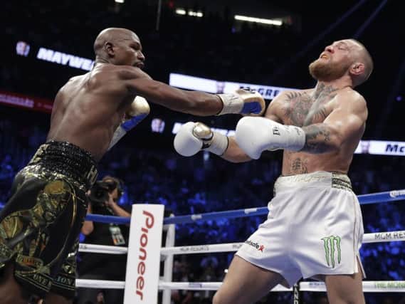 Mayweather lands a punch of McGregor. (AP Photo/Isaac Brekken)