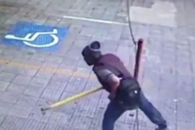 The suspect seen clutching a metal bar before the attack. (Photo: Policia Civil).