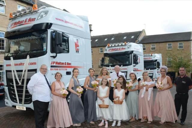 The wedding party in front of the trucks.