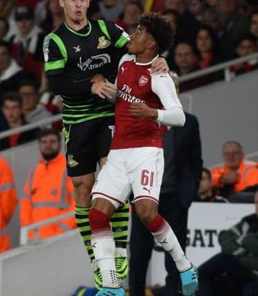 Doncaster's Tommy Rowe battles with Arsenal's Reiss Nelson