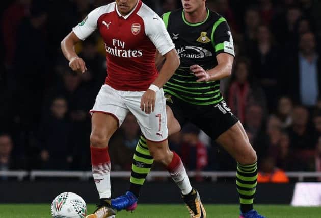 Doncaster's Jordan Houghton keeps close to Arsenal's Alexis Sanchez