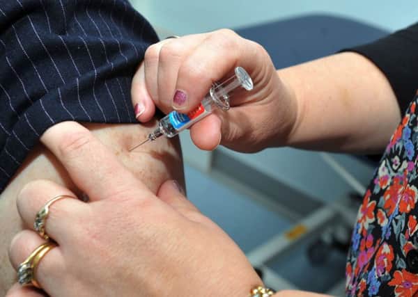 Nurse practitioner Julie Balmer, right, injects Doctor Kate Ardern, as she gets a flu jab to promote campaign to get members of the public vaccinated against the flu virus, at Worsley Mesnes Health Centre, Wigan.
