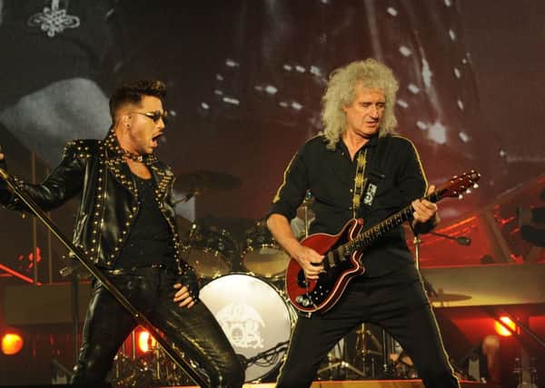 Adam Lambert and Queen's Brian May on stage.