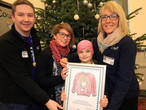 Tom Hogarty and Sian Dudley from Cast along with Abby Chandler from Doncaster Racecourse, present Amela with her prize during choir practice.
