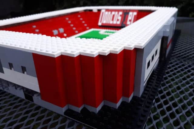 The design includes the coloured corner blocks of the stadium.