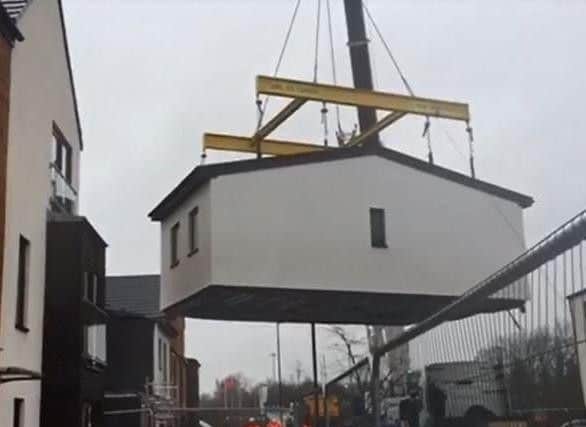 A huge crane lifts the upper floor of a new modular home into place on Woodfield Way