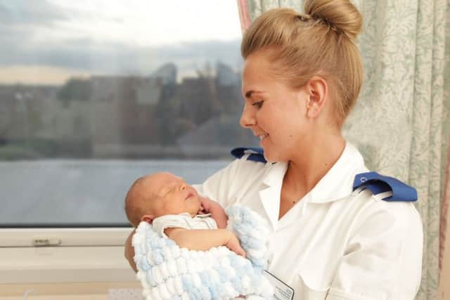 A midwife holds a newborn baby