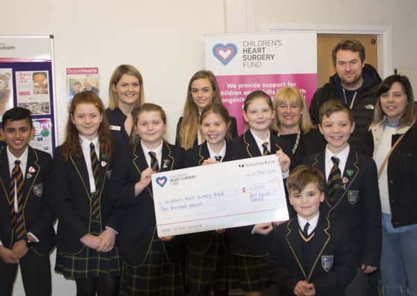 Toby Johns (front) and his parents (right) were delighted to present a cheque to CHSF representative Holly Rawlings (back left) along with Hill House School pupils