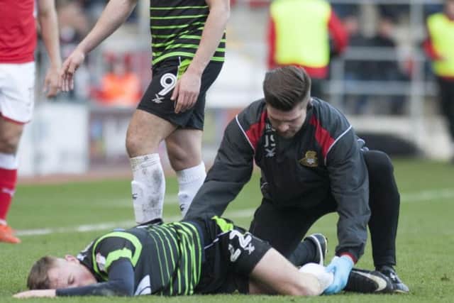 Alfie Beestin is given treatment after suffering ankle damage in a challenge