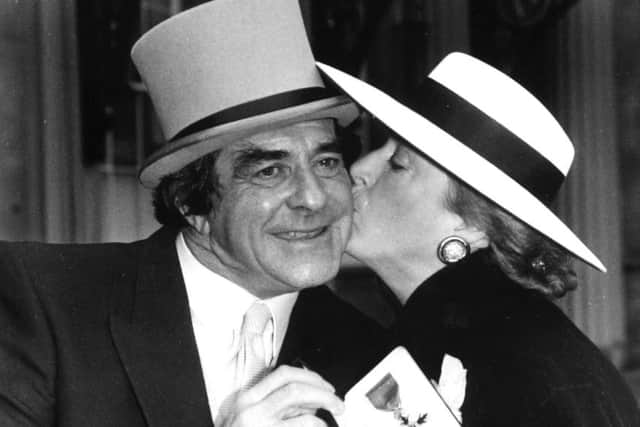 A kiss for cricket legend Freddie Trueman from his wife Veronica outside Buckingham Palace after his investiture as an OBE.