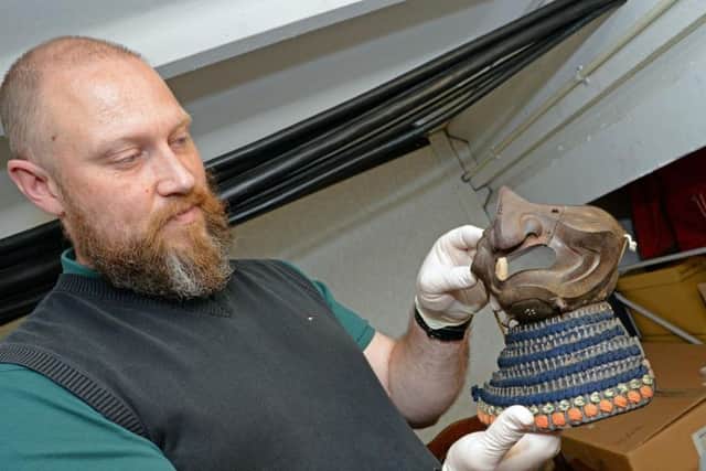 Caption:  Peter Robinson, Heritage Doncaster Curator of Human History, holds a Samurai Mask and detachable Neck guard. Picture: Marie Caley