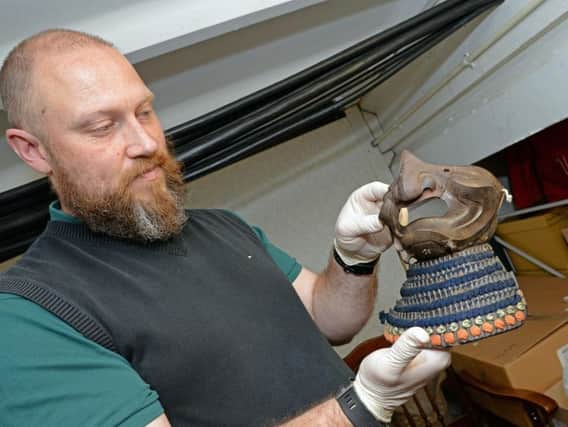 Caption:  Peter Robinson, Heritage Doncaster Curator of Human History, holds a Samurai Mask and detachable Neck guard. Picture: Marie Caley