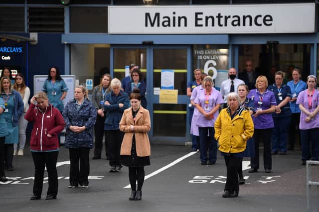 NHS workers hold a minute's silence outside the main entrance of Derriford Hospital on 28 April 2020 in Plymouth (Photo: Dan Mullan/Getty Images)